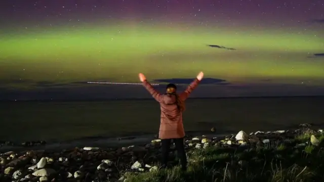 Michelle Cumming enjoying a display of the aurora with the lights of an RAF jet streaking across the sky