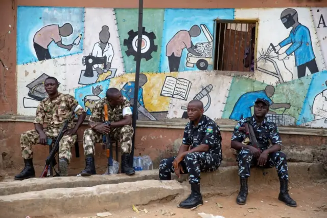 Soldiers and police guard the entrance to a vote collation centre