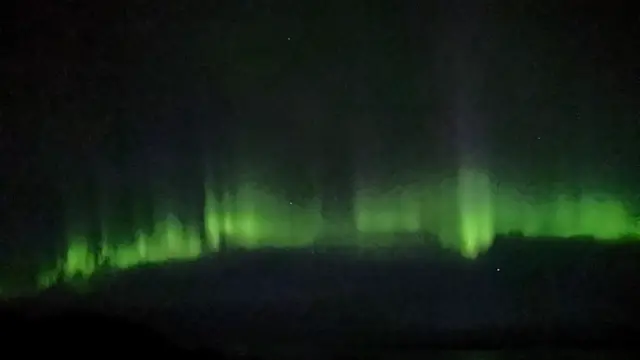 A green wave in the dark sky