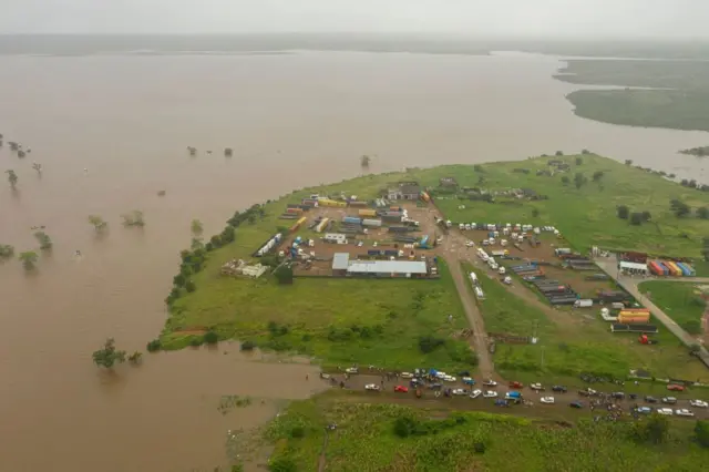 This aerial view shows floods of the Umbeluze river overflowing due to heavy rains in the Boane district of Maputo on February 11, 2023.