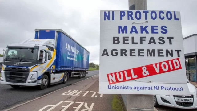 A lorry drives past a sign which reads: "NI Protocol makes Belfast Agreement null and void - unionists against NI Protocol"