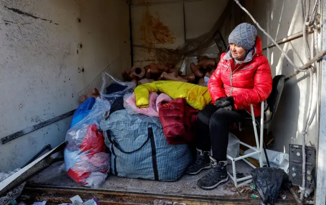 A woman is surrounded by the aftermath of shelling