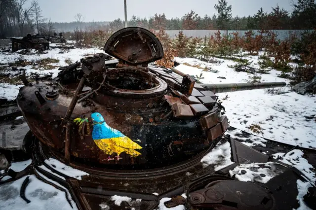 A blue and yellow bird painted on a destroyed Russian tank