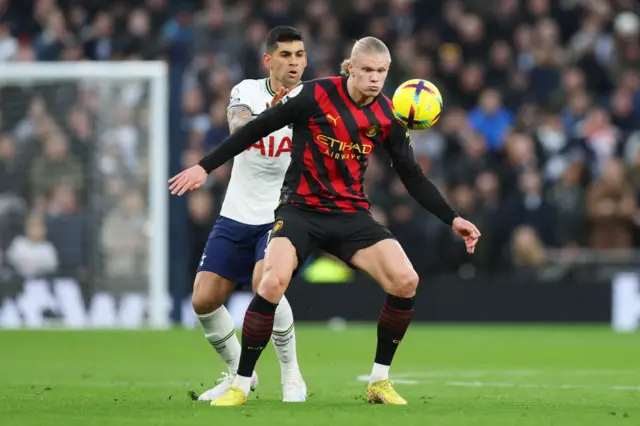 Erling Haaland is challenged by Cristian Romero