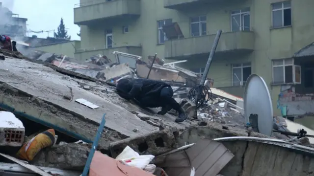 A man searches for survivors under the rubble after an earthquake in Kahramanmaras