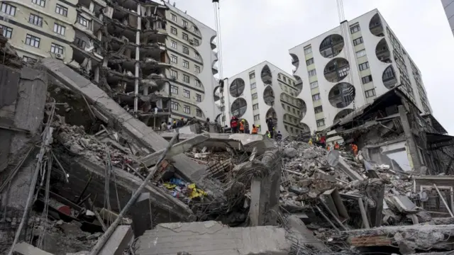 Emergency personnel search for victims at the site of a collapsed building after an earthquake in Diyarbakir, southeast of Turkey,