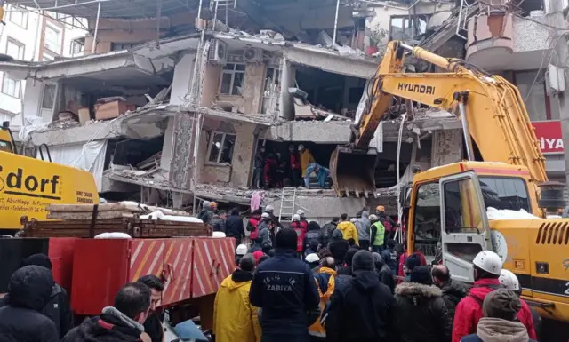 Emergency personnel search for victims at the site of a collapsed building after a powerful earthquake in Diyarbakir, south east of Turkey