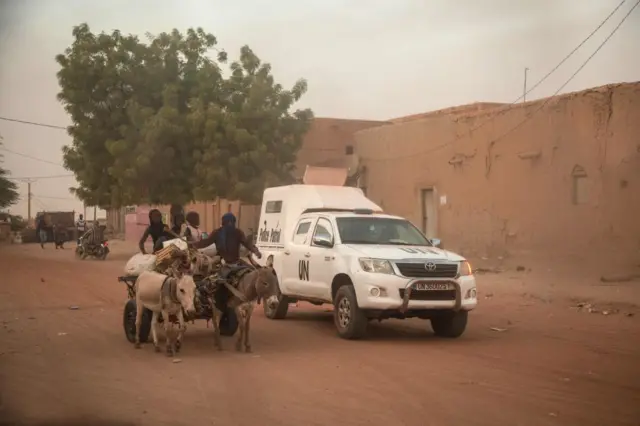 A donkey carriage passes an armoured vehicle of the United Nations Stabilisation Mission in Mali (MINUSMA) patrolling in Timbuktu, on December 9, 2021.