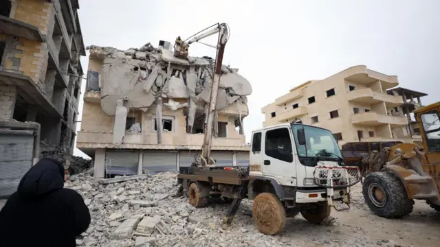 Rescuers work at the site of a collapsed building following an earthquake in Armanaz town, Idlib Governorate, Syria on 6 February 2023