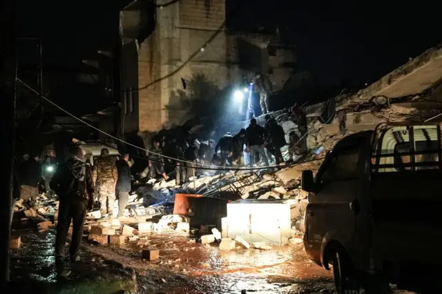 Civilians and fighters looking for victims in the town of Jandaris