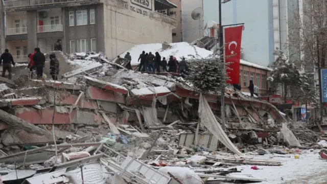 Rescuers carry out a person from a collapsed building after an earthquake in Malatya