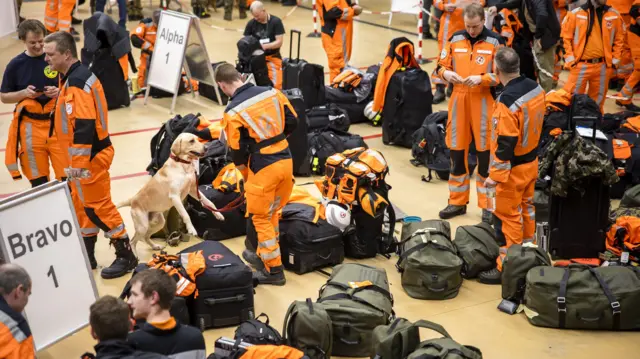 Rescuers with a dog and bags on the airport floor