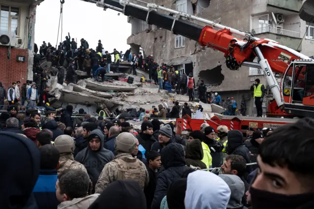 Rescuers search for survivors in the rubble of a collapsed building in the city of Diyarbakir