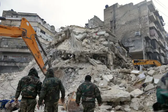 Rescue teams search for victims and survivors in the rubble of a collapsed building in the Syrian city of Aleppo