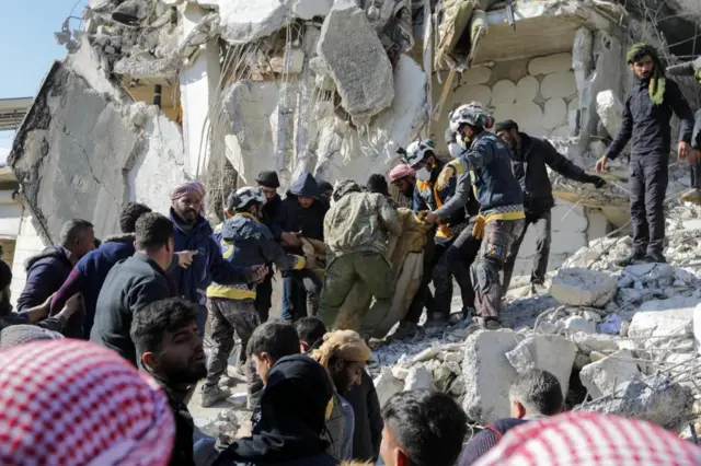 People searching for survivors in Jandaris, Syria