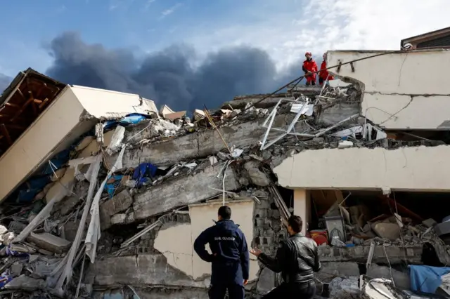 People searching the wreckage of a hospital in Iskenderun, Turkey