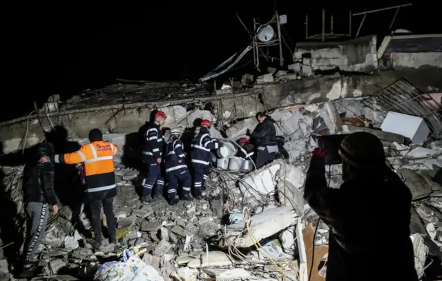 Rescuers search at the site of a collapsed building in Hatay, south-eastern Turkey