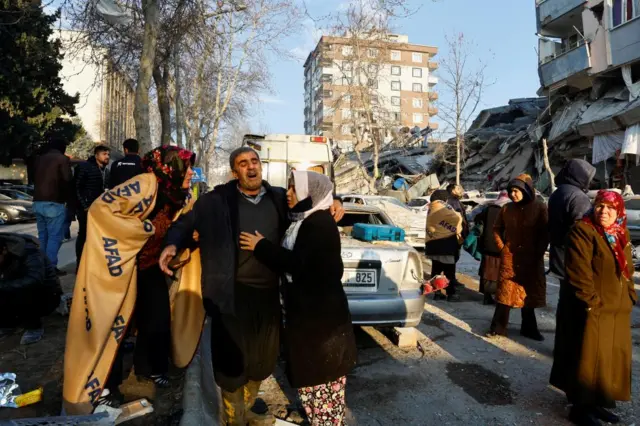 People, whose relatives are trapped under the rubble, react in the aftermath of a deadly earthquake in Kahramanmaras, Turkey