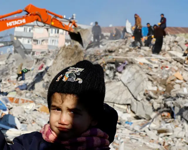 A child looks on in the aftermath of the deadly earthquake in Kahramanmaras, Turkey