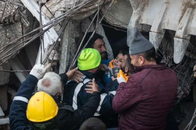 Eight-year-old Yigit Cakmak (C) is rescued from the site of a collapsed building, some 52 hours after a major earthquake, in Hatay, Turkey