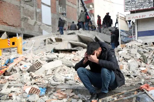 Man sitting on rubble in Diyarbakir, Turkey