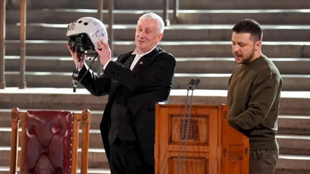 Speaker of the House of Commons, Sir Lindsay Hoyle (left), holds the helmet of one of the most successful Ukrainian pilots