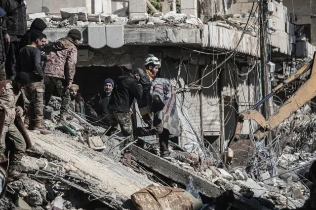 ALEPPO, SYRIA - FEBRUARY 07: A member of the search and rescue team carries the dead body of a child who died under the rubble in the earthquake in Afrin district of Aleppo, Syria after 7.7 and 7.6 magnitude earthquakes hits Turkiye's Kahramanmaras, on February 07, 2023. As a result of the earthquake, at least 1602 people lost their lives in different parts of Syria, more than 3,649 people were injured. Early Monday morning, a strong 7.7 earthquake, centered in the Pazarcik district, jolted Kahramanmaras and strongly shook several provinces, including Gaziantep, Sanliurfa, Diyarbakir, Adana, Adiyaman, Malatya, Osmaniye, Hatay, and Kilis. Later, at 13.24 p.m. (1024GMT), a 7.6 magnitude quake centered in Kahramanmaras' Elbistan district struck the region. Turkiye declared 7 days of national mourning after deadly earthquakes in southern provinces. (Photo by Omer Alven/Anadolu Agency via Getty Images)