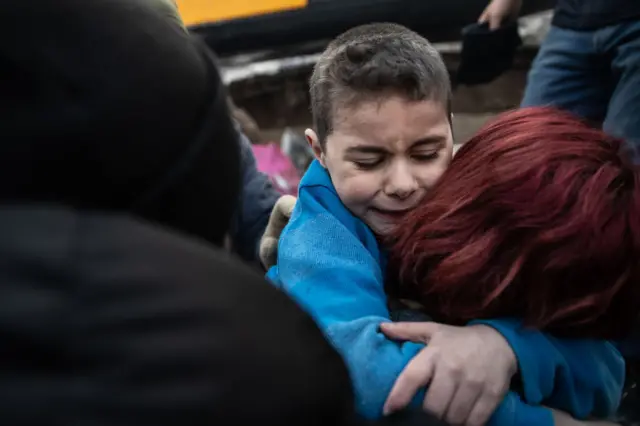 Yigit Cakmak hugs his mother after being rescued