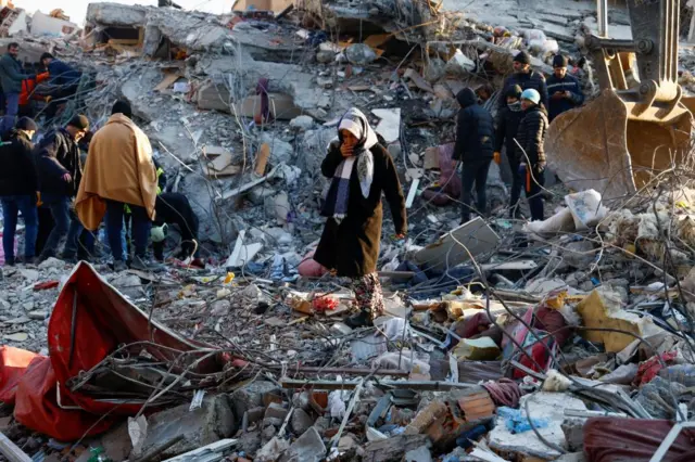 A woman looks at the destruction following an earthquake in Kahramanmaras, Turkey