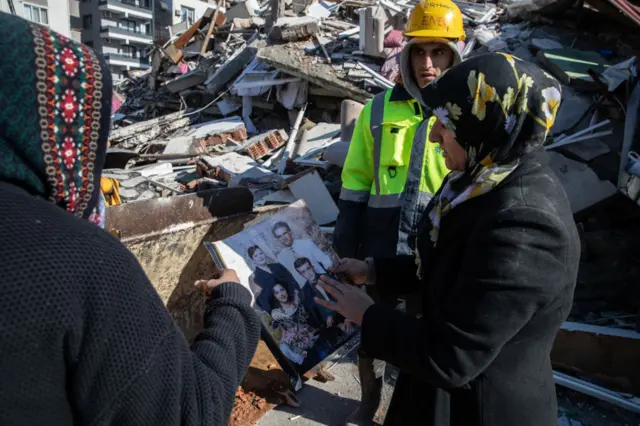 A rescue worker shows an family photos to identify the victim found dead in the collapsed building on February 08, 2023 in Hatay, Turkey.