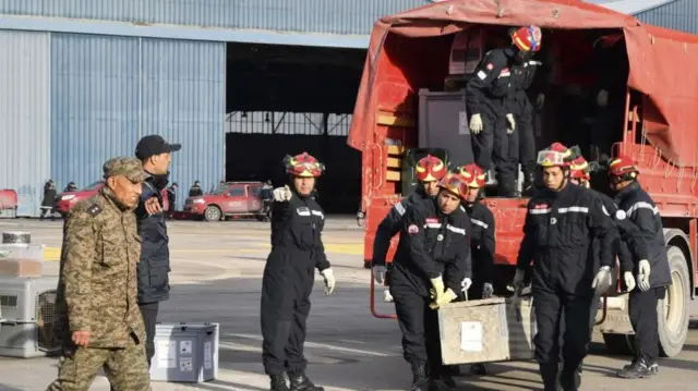 Tunisian emergency responders load aid to Syria and Turkey into military planes at L'Aouina military airport on 7 February 2023