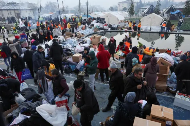 People look through boxes of aid materials in Hatay, Turkey