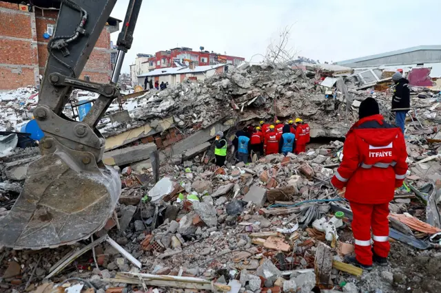 Emergency personnel and locals search the site of a collapsed building in the Elbistan district of Kahramanmaras