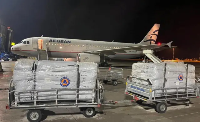 Aid materials from the Greek Ministry of Civil Protection are prepared to be loaded on a plane from Athens, Greece