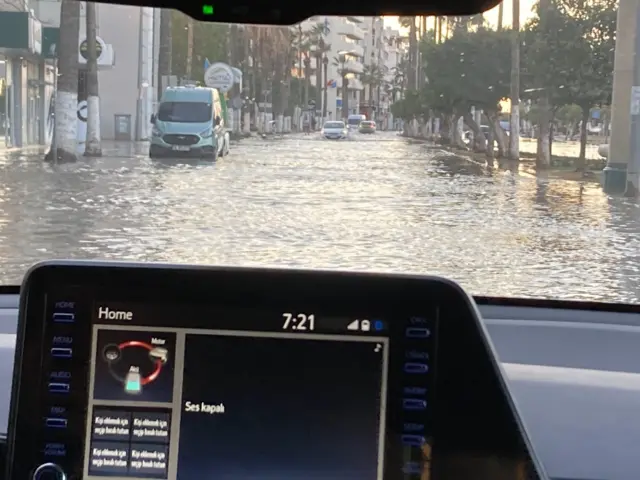 A road submerged in water viewed from a car window