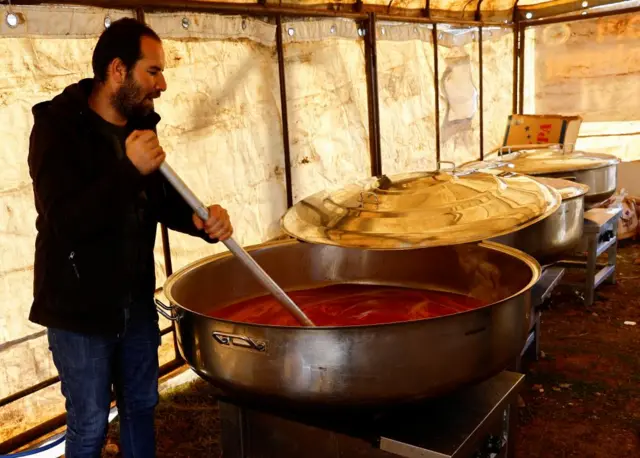 A man prepares food for those affected, in the aftermath of a deadly earthquake, in Pazarcik, Turkey