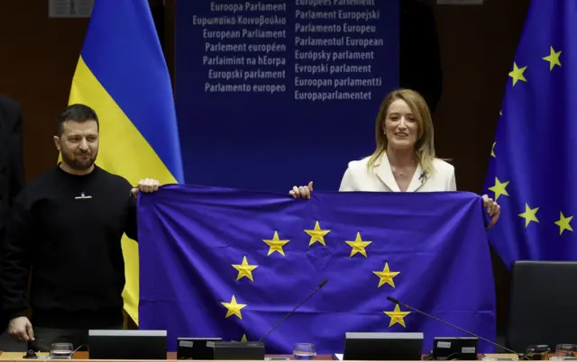 Zelensky is presented with European Union flag by Roberta Metsola the president of the European Parliament