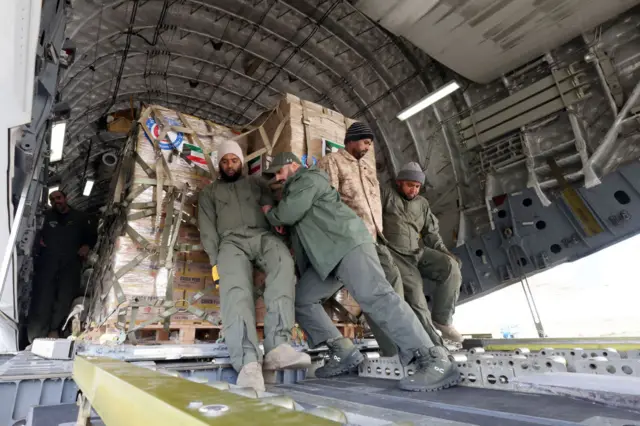 Kuwaiti army soldiers load a military plane with humanitarian aid for Turkey, in Kuwait City, Kuwait