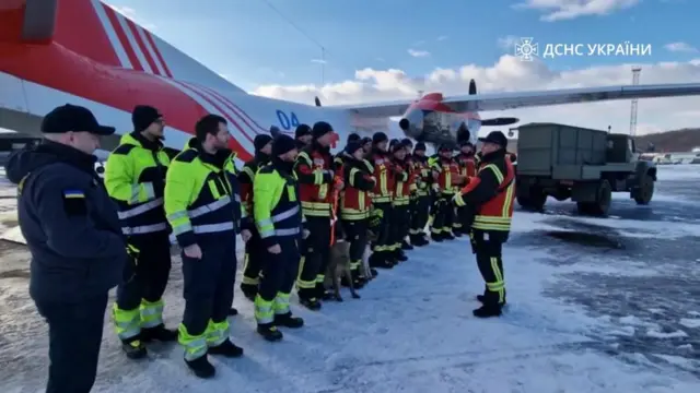 Personnel from the Ukrainian State Emergency Service line up ready to board a flight to the earthquake zone