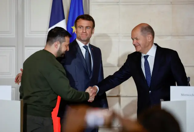 Ukraine's President Volodymyr Zelensky and German Chancellor Olaf Scholz shake hands during a joint statement with French President Emmanuel Macron, at the Elysee Palace in Paris, France, 08 February 2023.