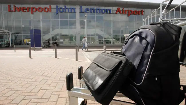 Luggage on trolley outside of Liverpool John Lennon Airport