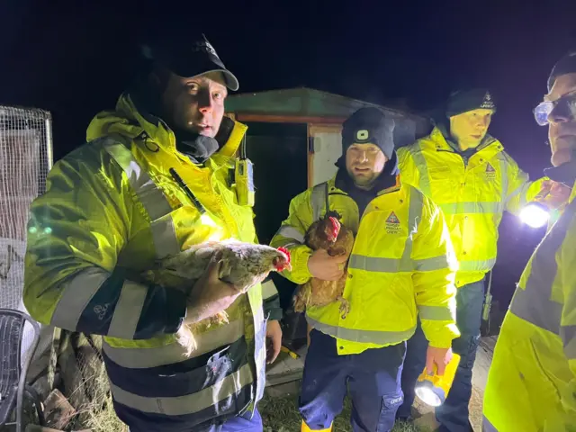 Lifeboat crews with the rescued chickens