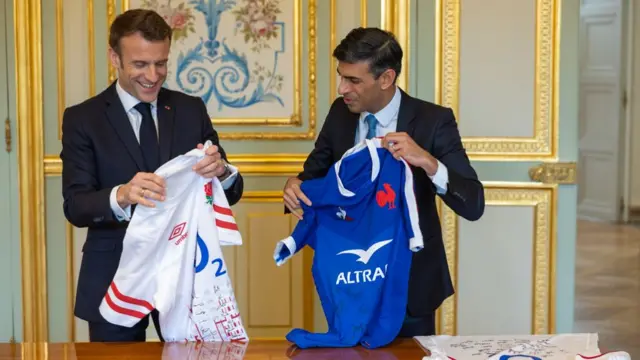 Prime Minister Rishi Sunak exchanges gifts with the President of France Emmanuel Macron at the Elysee Palace