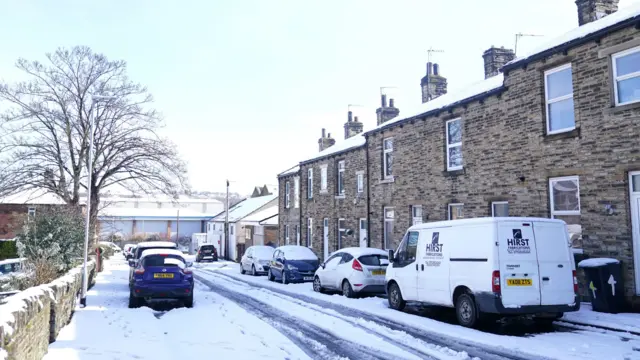 A road with cars covered in snow