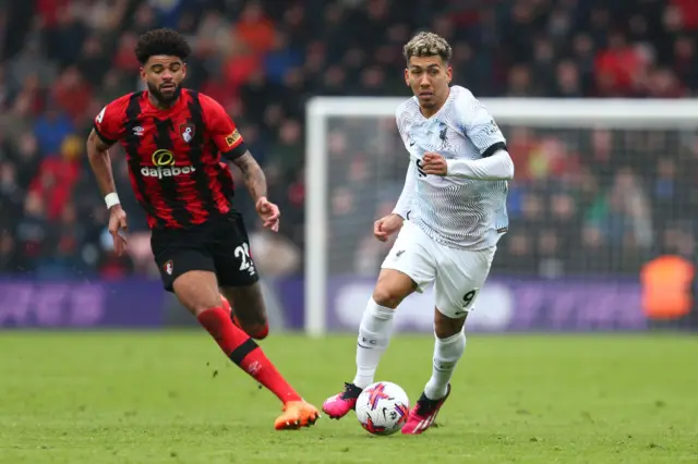 Roberto Firmino of Liverpool runs with the ball while under pressure from Philip Billing of AFC Bournemouth during the Premier League match between AFC Bournemouth and Liverpool FC at Vitality Stadium