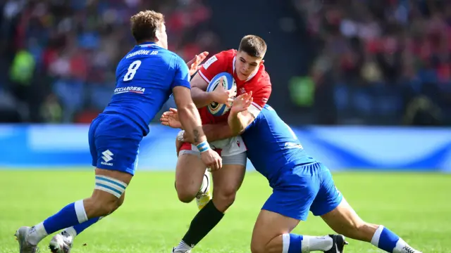 Joe Hawkins is tackled by Lorenzo Cannone and Michele Lamaro