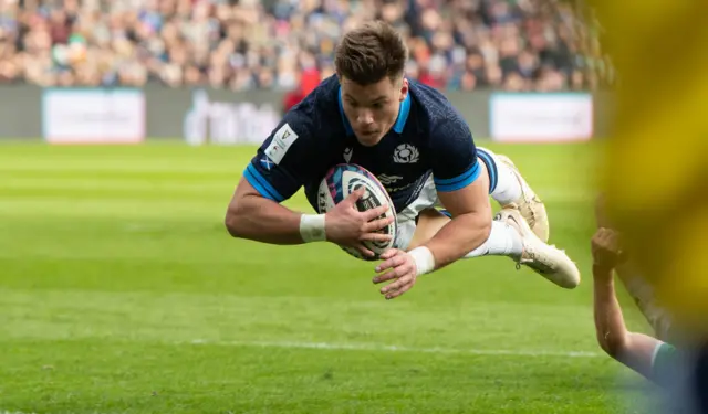 Huw Jones dives over for the first try of the day