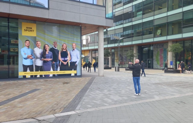 A man takes a photo of the BBC Salford studio