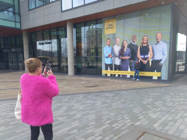 A woman takes a photo of the BBC studio at Salford