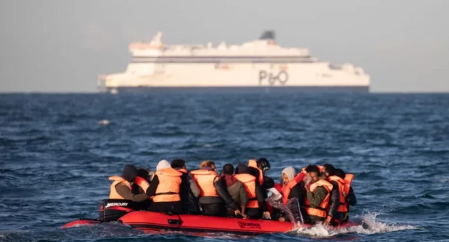 Migrants cross the English Channel on a small boat